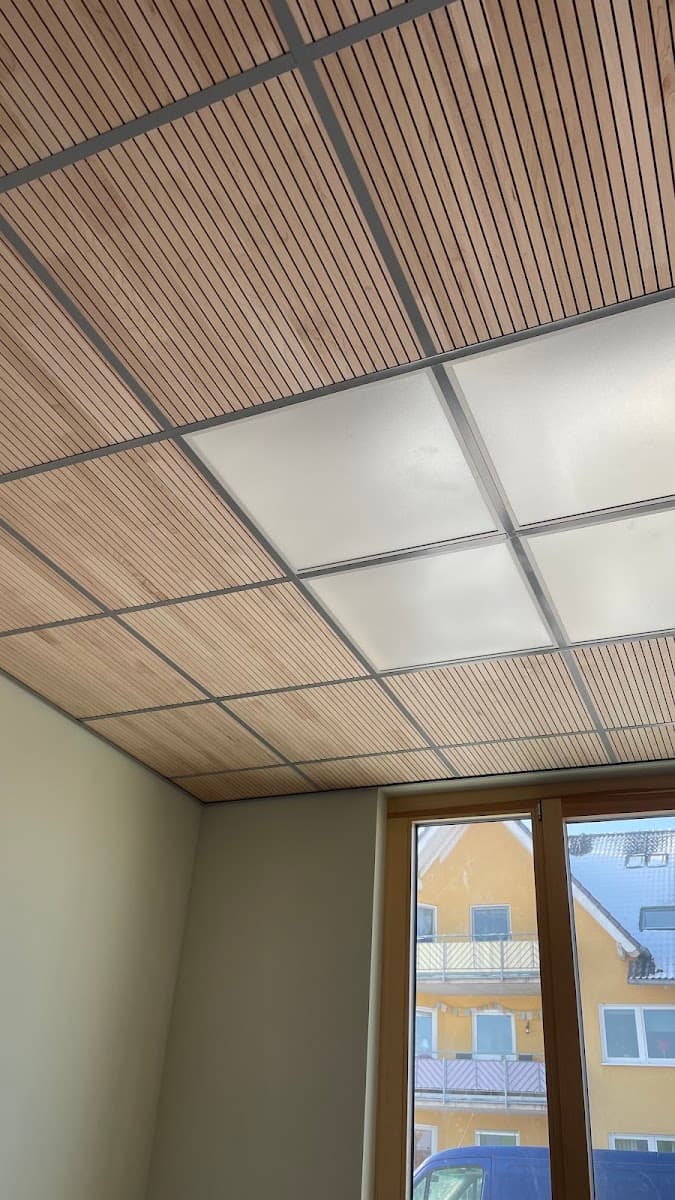 Holz-Lamellen-Akustikdecke mit Rasterfeldern und Lichtpaneelen