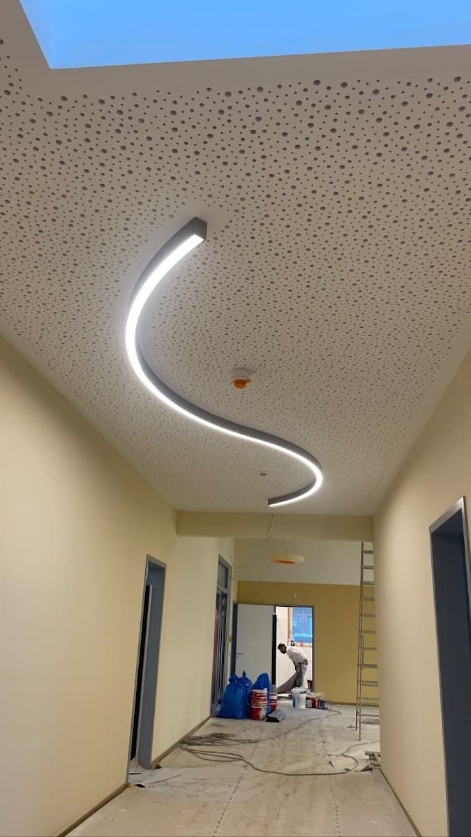 Geschwungener LED-Lichtkanal in einer gelochten Akustikdecke